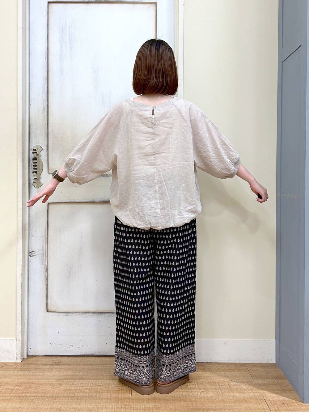 ブラウン系のショルダーバッグ、ブラック系のその他パンツ、ホワイト系のタンクトップを着用したレディースの春コーディネートの4枚目の写真