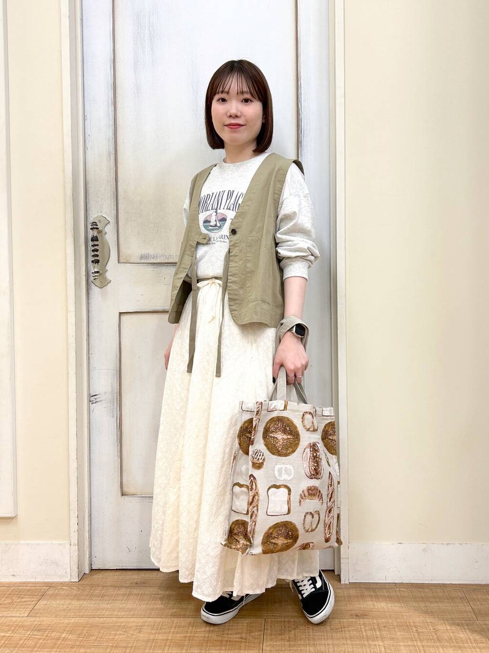 グリーン系のベスト、その他のTシャツ/カットソー、ホワイト系のスカートを着用したレディースの春コーディネートの6枚目の写真