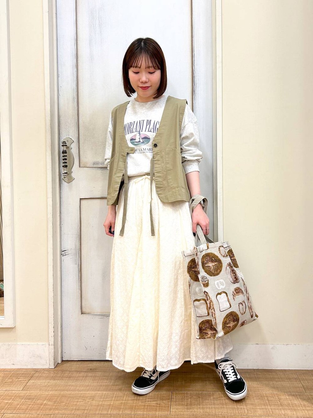 グリーン系のベスト、その他のTシャツ/カットソー、ホワイト系のスカートを着用したレディースの春コーディネートの2枚目の写真