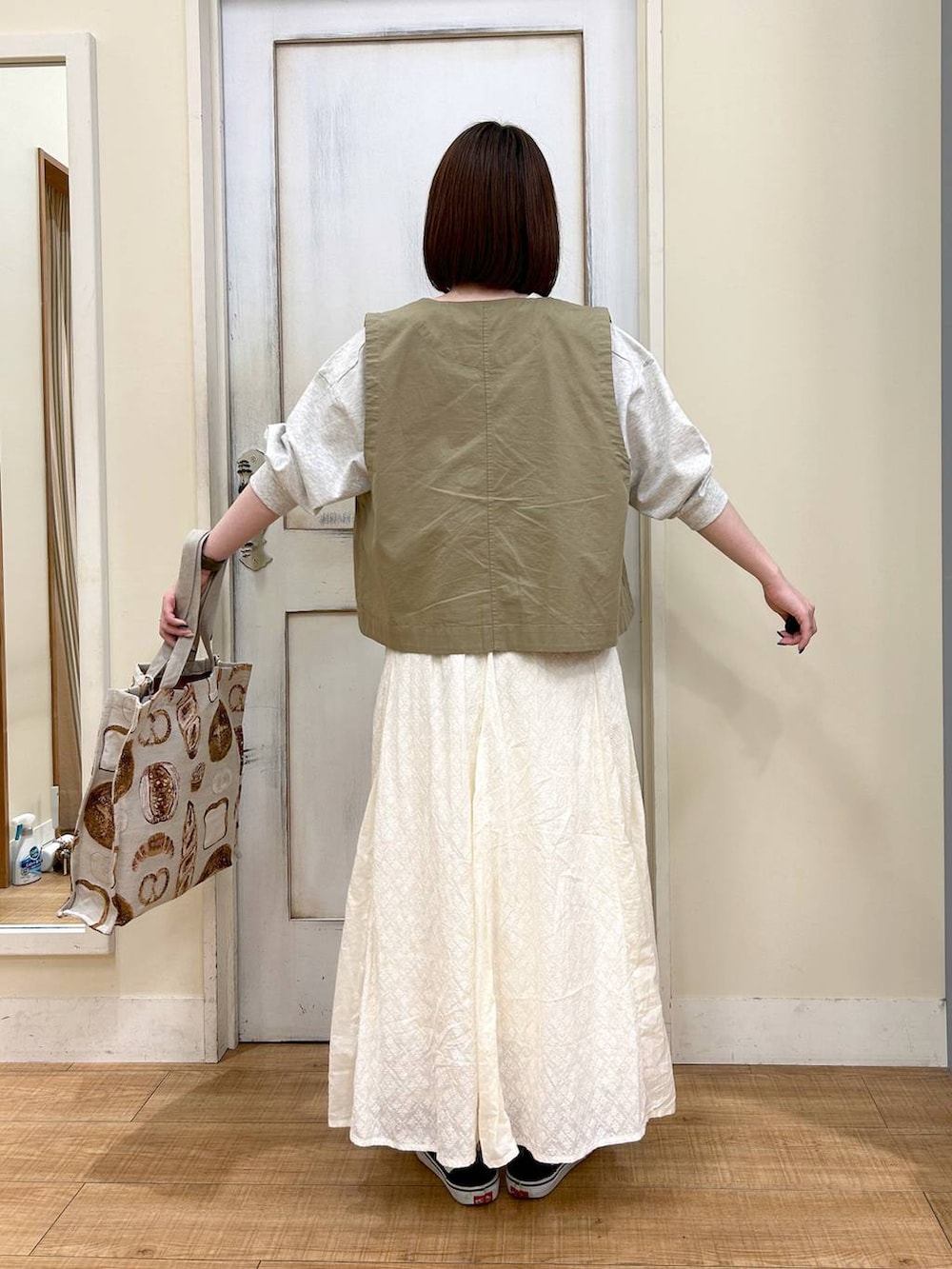 グリーン系のベスト、その他のTシャツ/カットソー、ホワイト系のスカートを着用したレディースの春コーディネートの4枚目の写真