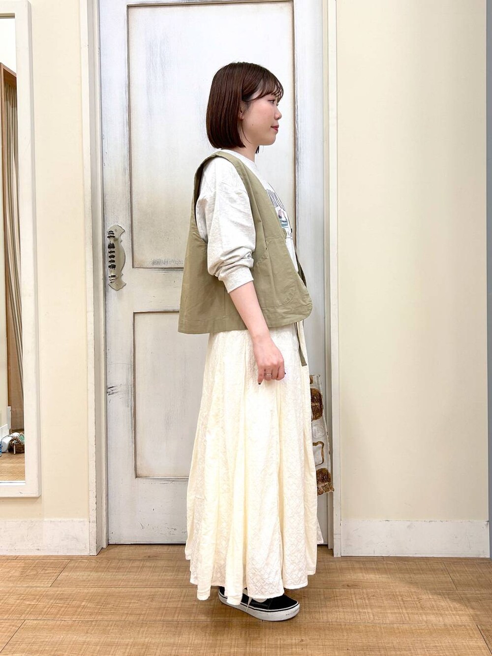 グリーン系のベスト、その他のTシャツ/カットソー、ホワイト系のスカートを着用したレディースの春コーディネートの5枚目の写真