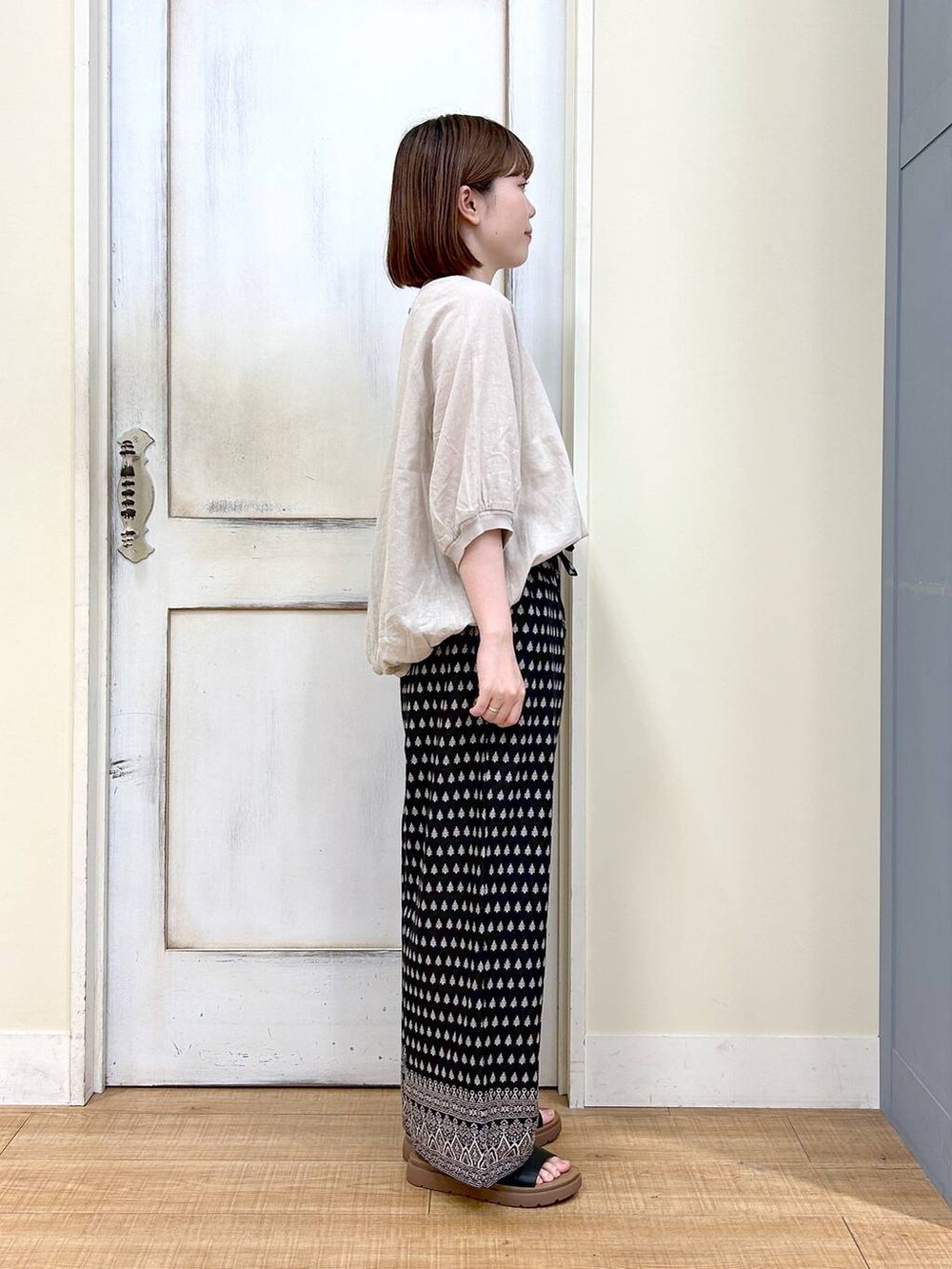 ブラウン系のショルダーバッグ、ブラック系のその他パンツ、ホワイト系のタンクトップを着用したレディースの春コーディネートの5枚目の写真