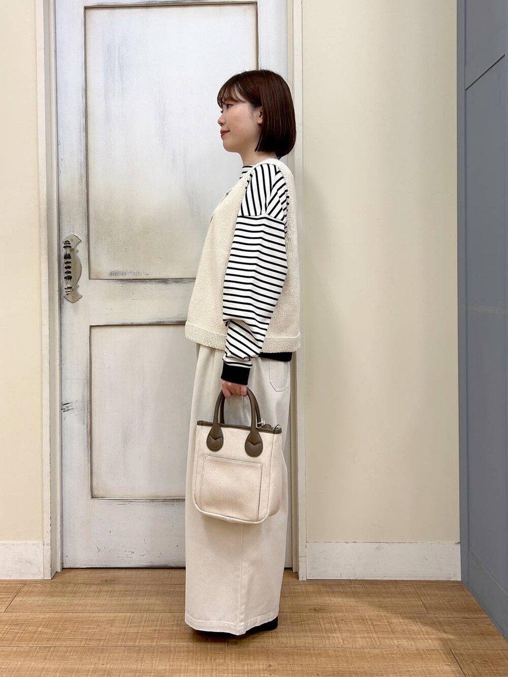 ホワイト系のトートバッグ、ブラウン系のスニーカー、ベージュ系のその他パンツを着用したレディースの春コーディネートの3枚目の写真