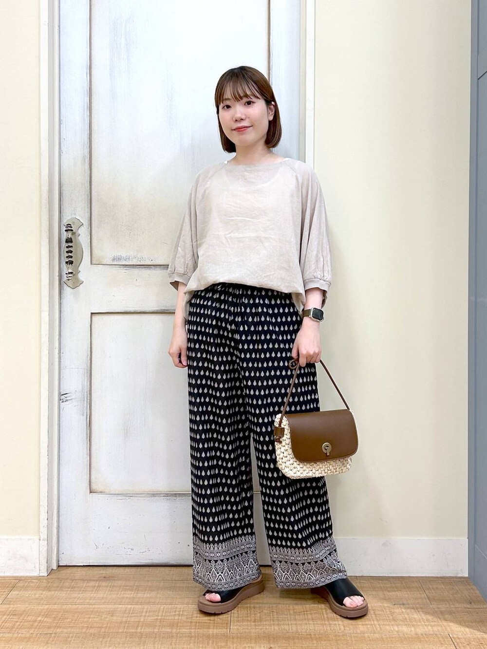 ブラウン系のショルダーバッグ、ブラック系のその他パンツ、ホワイト系のタンクトップを着用したレディースの春コーディネートの8枚目の写真