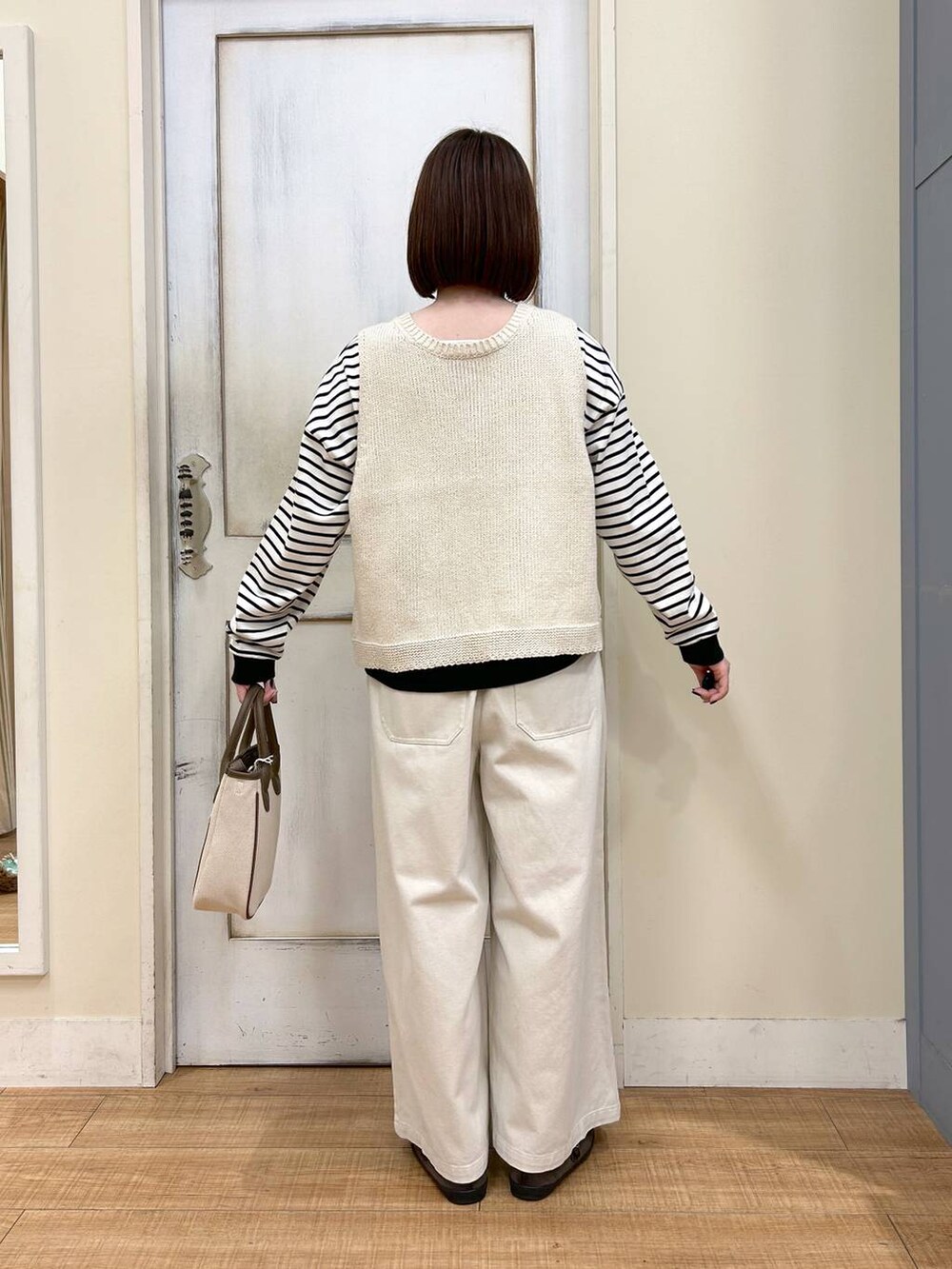 ホワイト系のトートバッグ、ブラウン系のスニーカー、ベージュ系のその他パンツを着用したレディースの春コーディネートの4枚目の写真