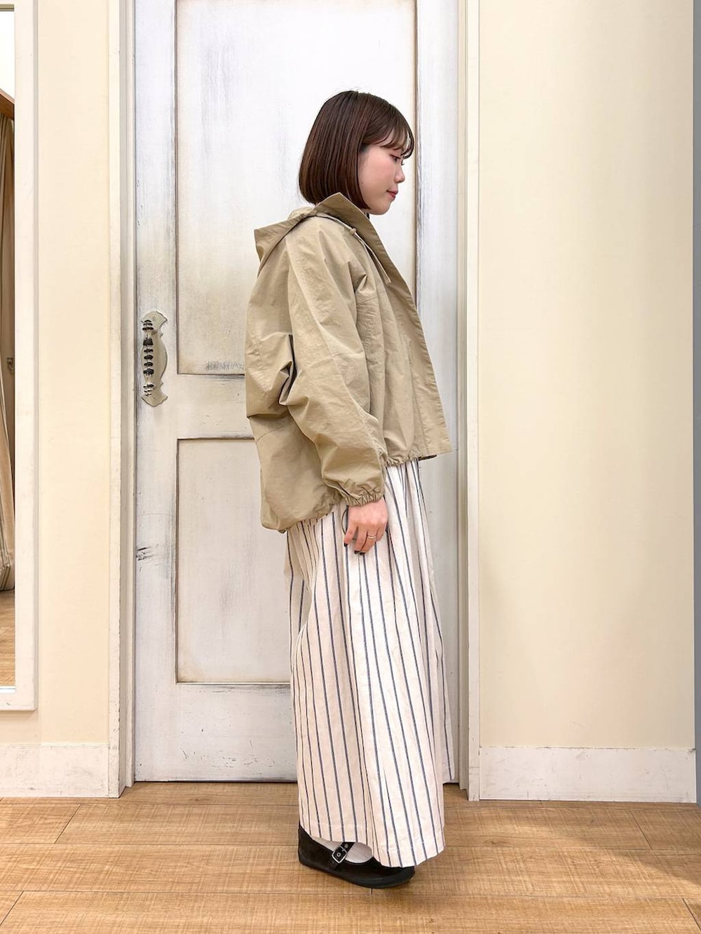 ブラウン系のTシャツ/カットソー、ブラウン系のスニーカー、ベージュ系のマウンテンパーカーを着用したレディースの春コーディネートの6枚目の写真