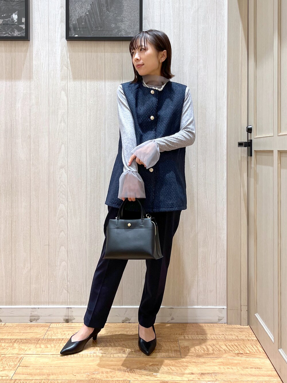 ブルー系のベスト、ブルー系のその他パンツ、ブラック系のトートバッグを着用したレディースの冬コーディネートの2枚目の写真