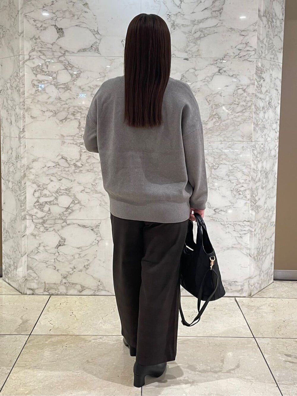 レッド系のTシャツ/カットソー、グレー系のカーディガン/ボレロ、ブラウン系のその他パンツを着用したレディースの秋コーディネートの3枚目の写真