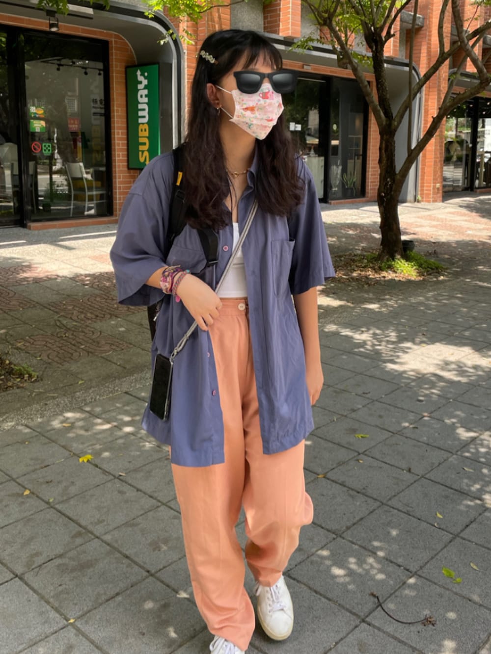 パープル系のトップス、ピンク系の腕時計、レッド系のメガネを着用したレディースの夏コーディネートの2枚目の写真