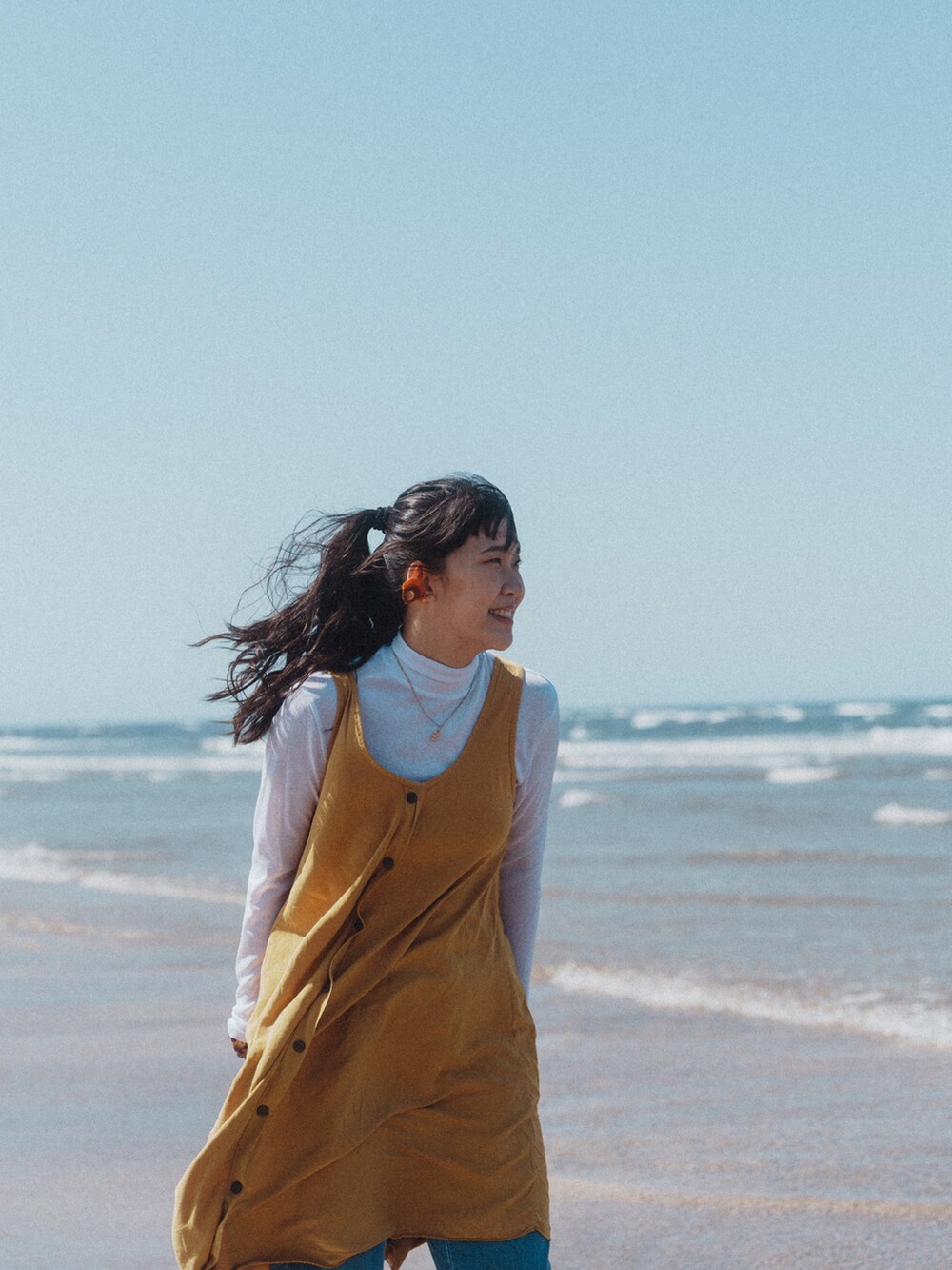 ブルー系のデニムパンツ、ピンク系の腕時計を着用したレディースの春コーディネートの2枚目の写真