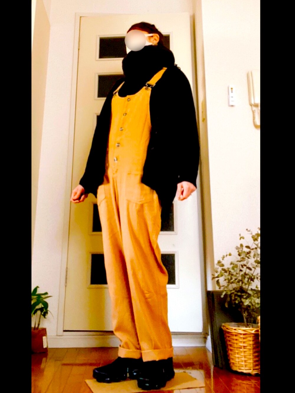 ブラウン系のサロペット/オーバーオール、ブラック系のスニーカー、ブラック系のニット/セーターを着用したレディースの春コーディネートの2枚目の写真