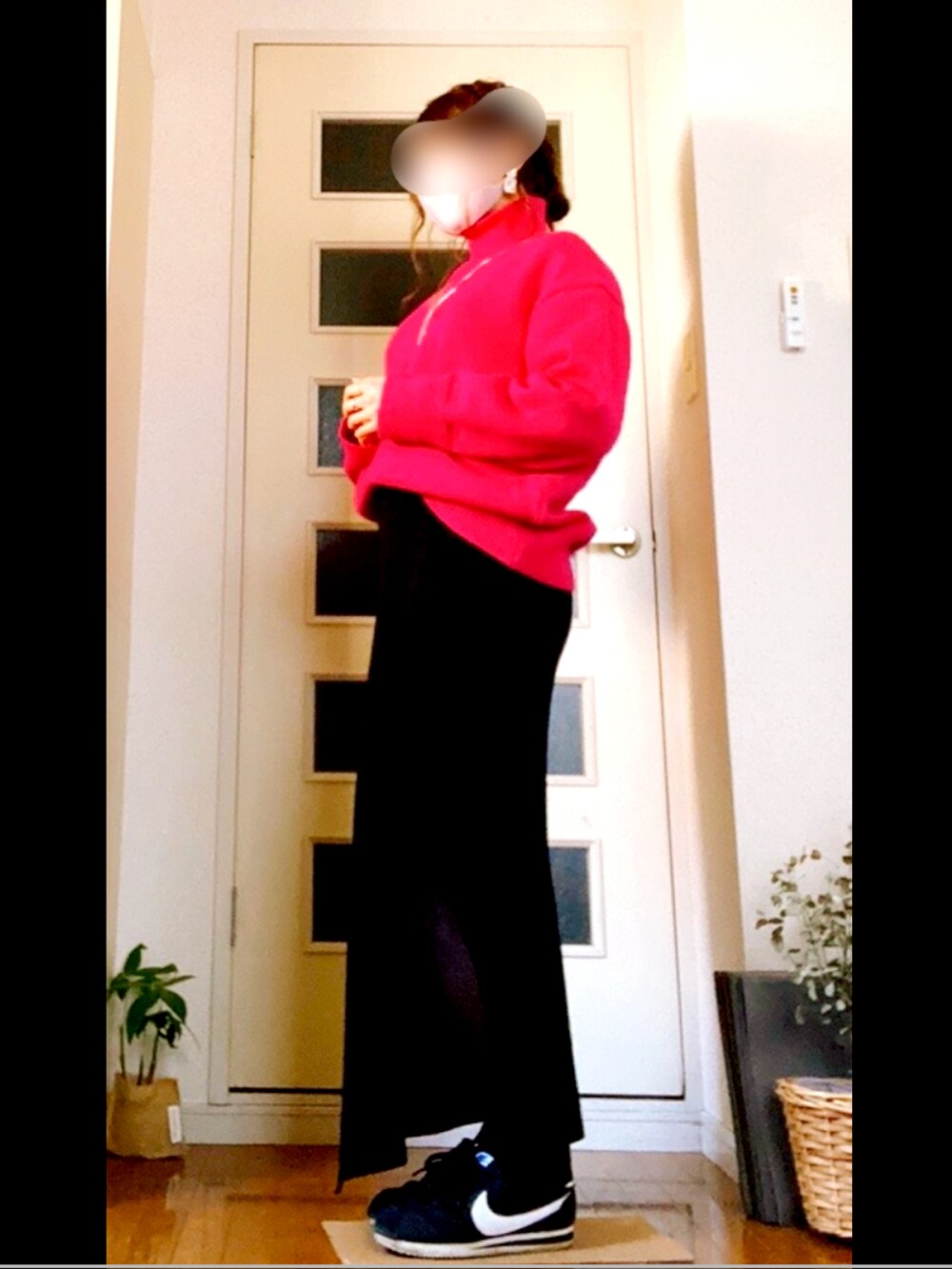 ピンク系のニット/セーター、ブラック系のスカート、ブラック系のスニーカーを着用したレディースの春コーディネートの3枚目の写真