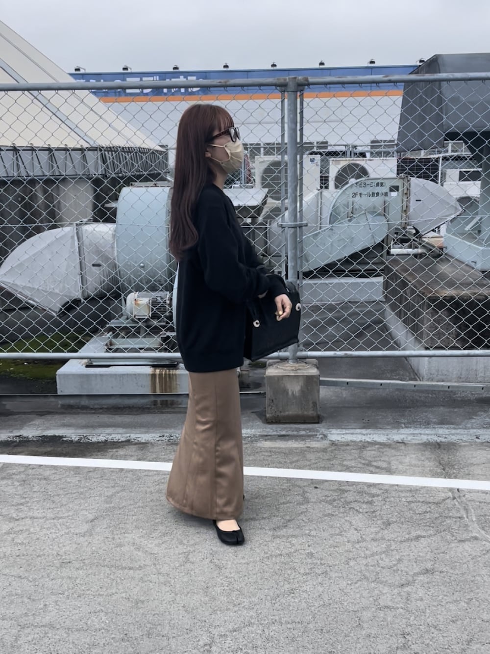 ブラック系のハンドバッグを着用したレディースの春コーディネートの2枚目の写真