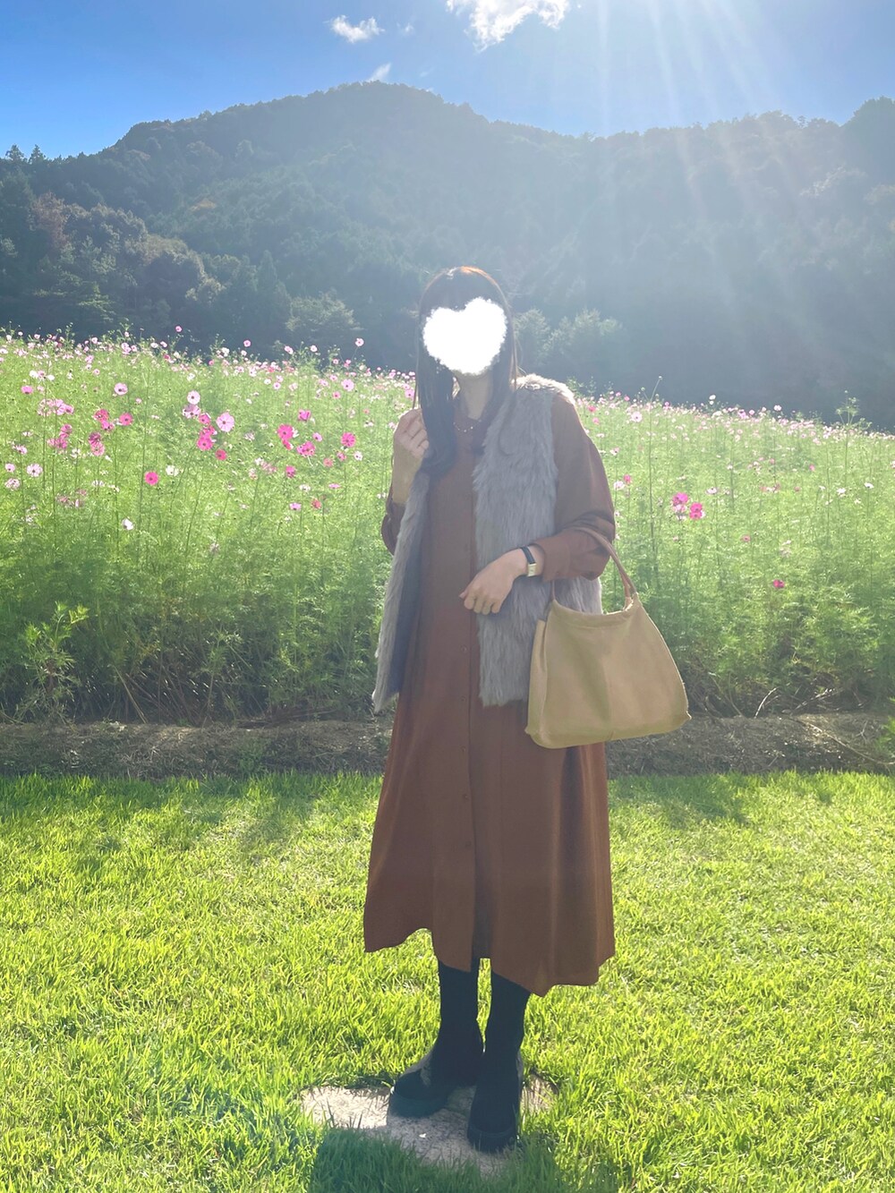 ブラウン系のワンピース、ブラウン系のベスト、ブラック系のアナログ腕時計を着用したレディースの秋コーディネートの2枚目の写真