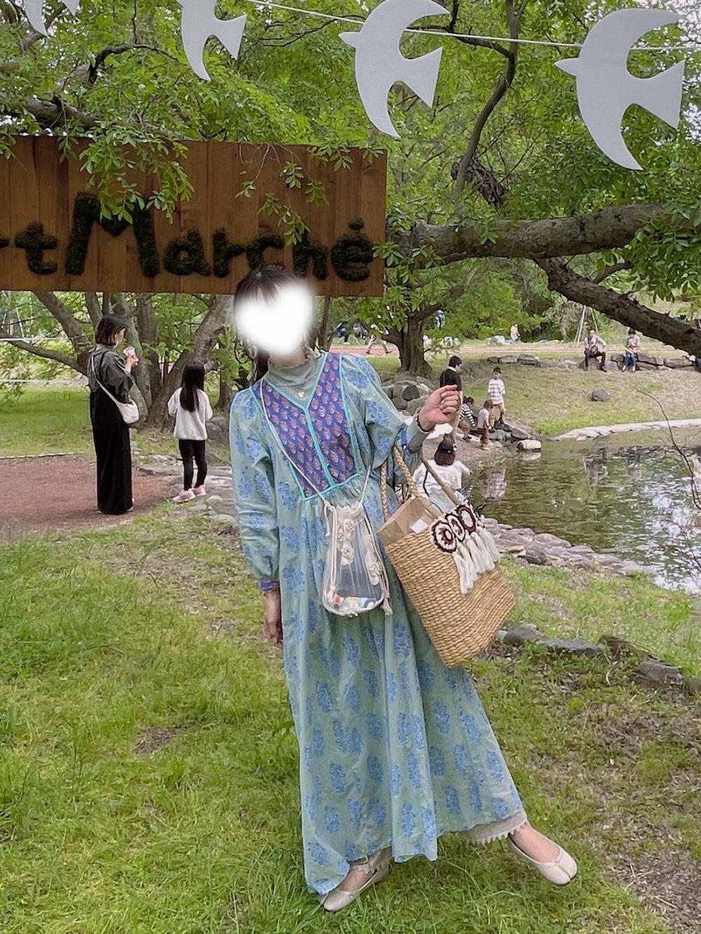 グリーン系のワンピース、ホワイト系のショルダーバッグ、ホワイト系のハンドバッグを着用したレディースの春コーディネートの2枚目の写真