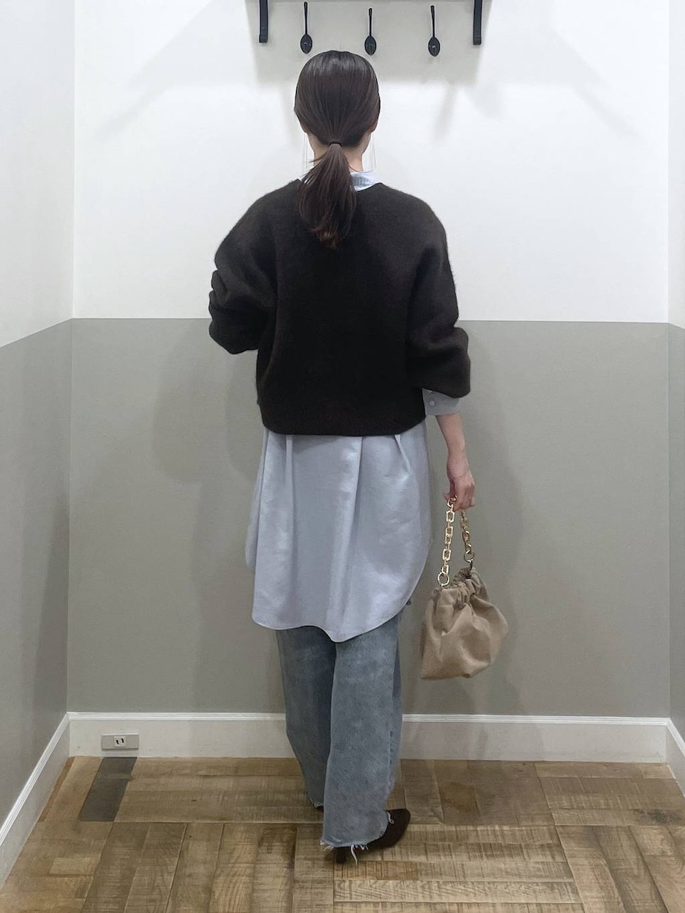 ブラウン系のカーディガン/ボレロ、ブルー系のデニムパンツ、ベージュ系のショルダーバッグを着用したレディースの秋コーディネートの2枚目の写真