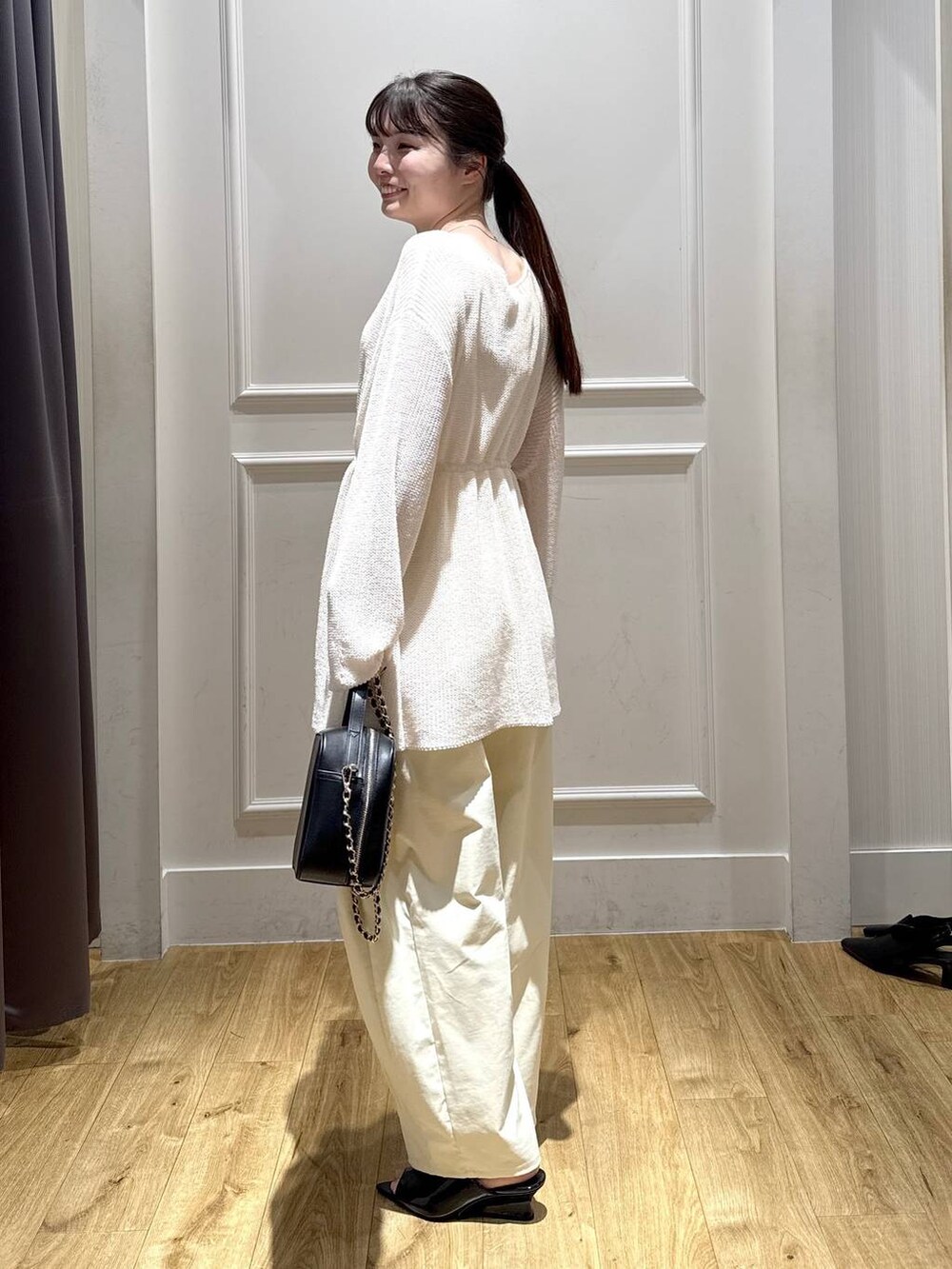 ホワイト系のカーディガン/ボレロ、ブラック系のサンダル、ブラック系のショルダーバッグを着用したレディースの春コーディネートの3枚目の写真