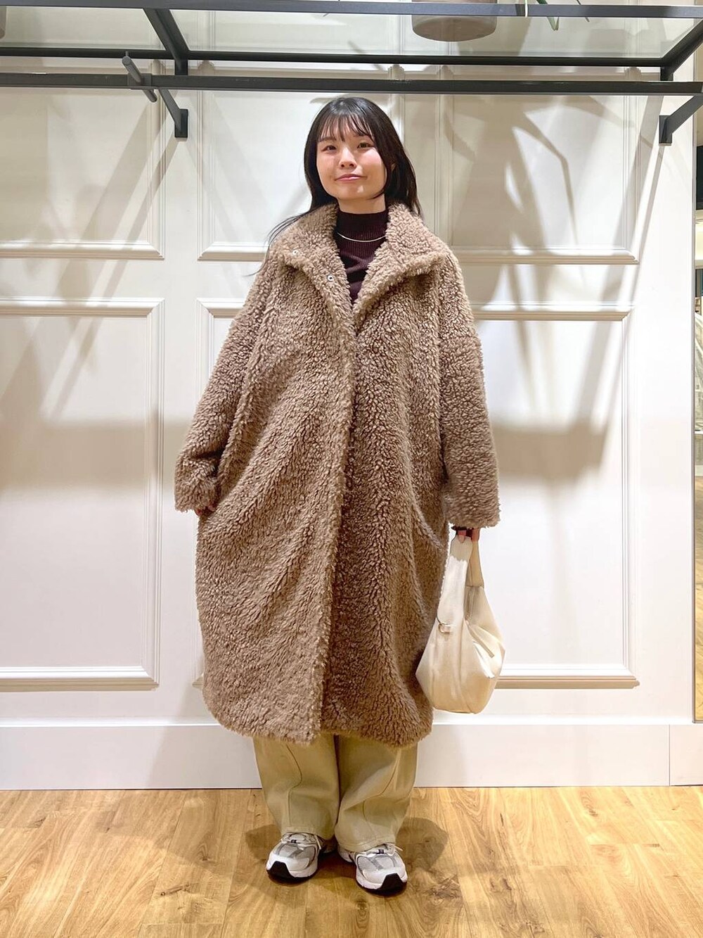 ベージュ系のデニムパンツ、ホワイト系のハンドバッグ、ベージュ系のその他アウターを着用したレディースの冬コーディネートの5枚目の写真