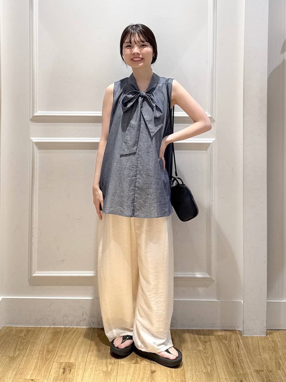 ホワイト系のその他パンツ、ブルー系のシャツ/ブラウス、ブラック系のショルダーバッグを着用したレディースの夏コーディネートの5枚目の写真