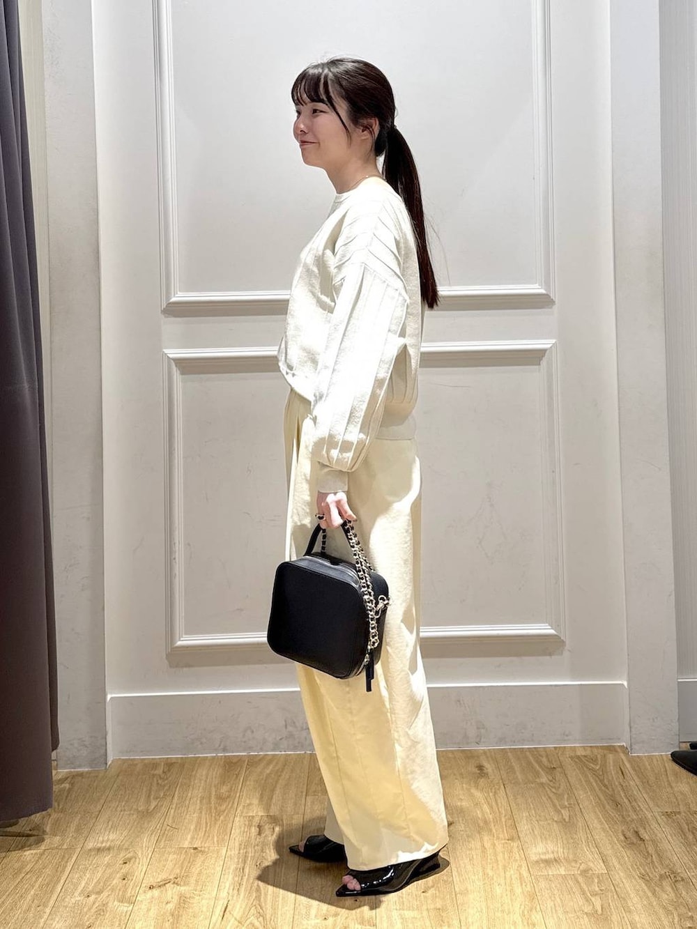 ホワイト系のカーディガン/ボレロ、ブラック系のサンダル、ブラック系のショルダーバッグを着用したレディースの春コーディネートの4枚目の写真