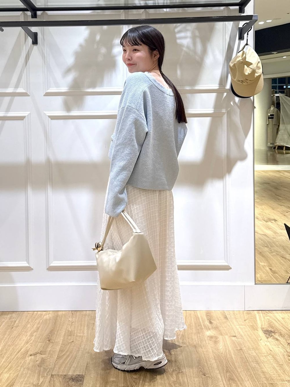 ブルー系のカーディガン/ボレロ、ホワイト系のスカートを着用したレディースの春コーディネートの3枚目の写真