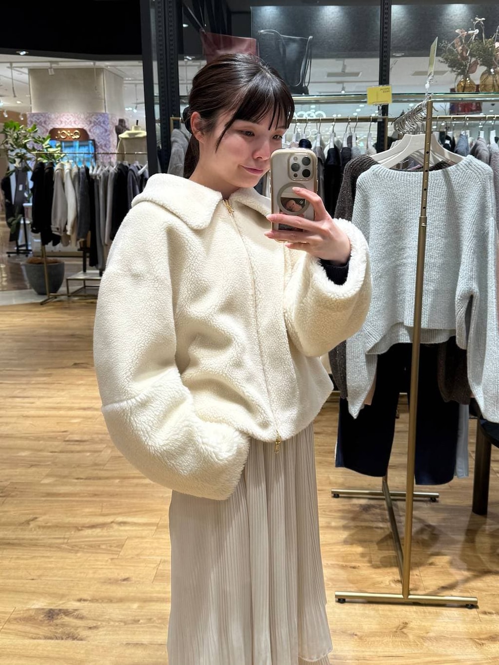 ホワイト系のスカート、ホワイト系のブルゾンを着用したレディースの冬コーディネートの3枚目の写真