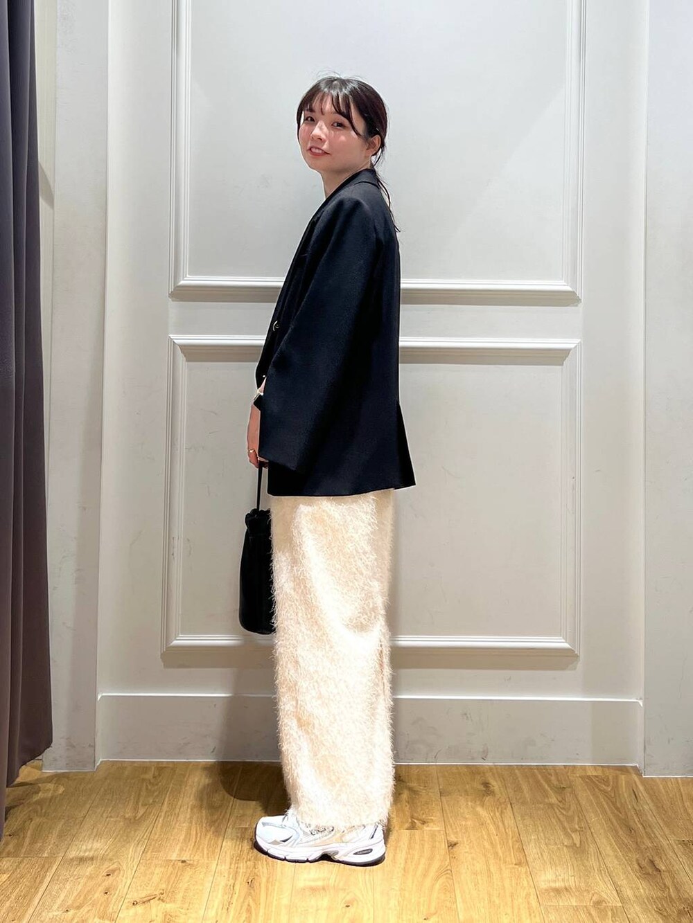 ブラック系のテーラードジャケット、ブラック系のショルダーバッグ、ブラウン系のタンクトップを着用したレディースの秋コーディネートの3枚目の写真