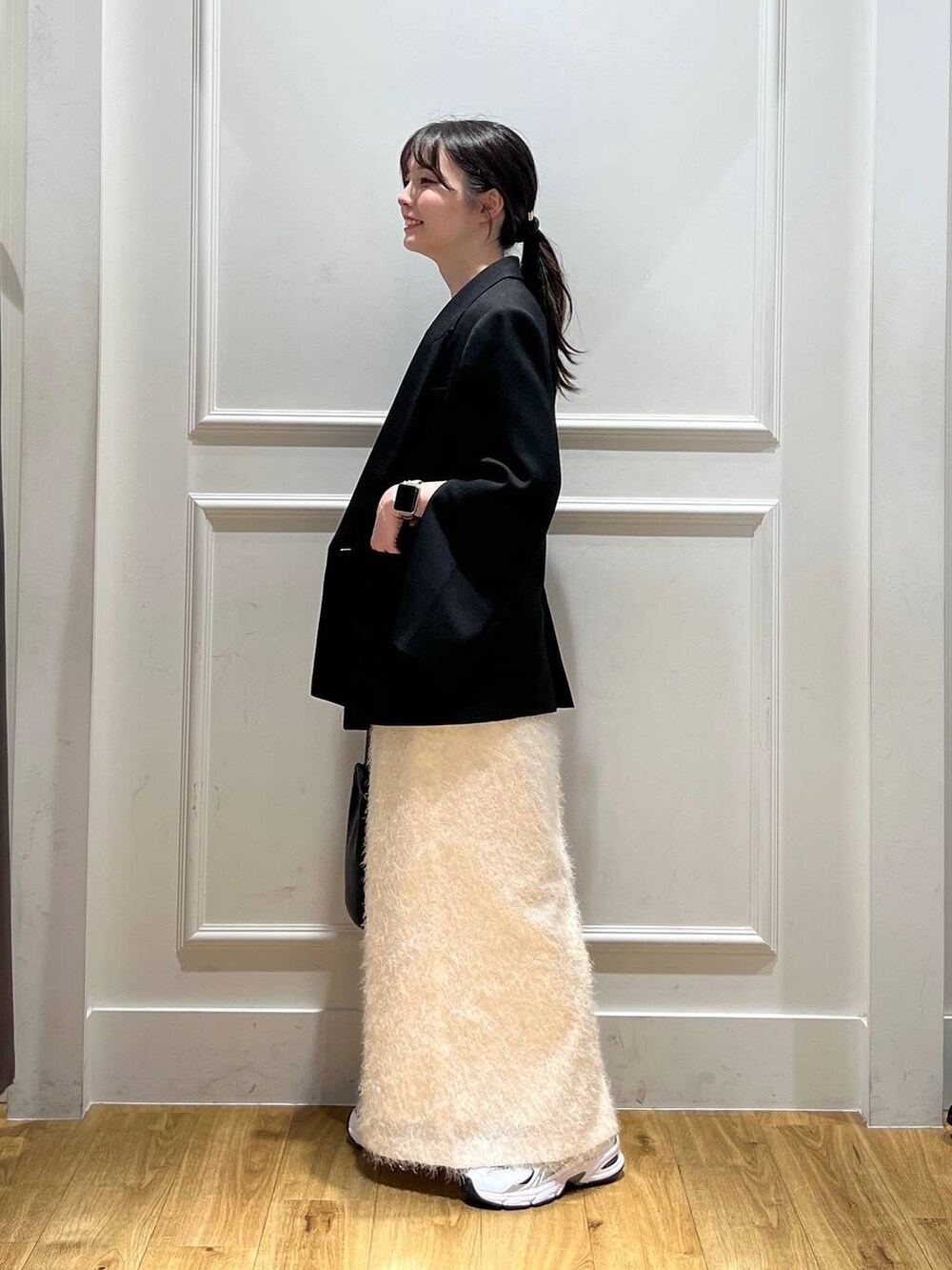 ブラック系のテーラードジャケット、ブラック系のショルダーバッグ、ブラウン系のタンクトップを着用したレディースの秋コーディネートの2枚目の写真