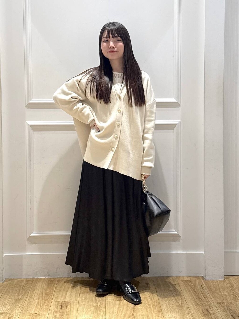 ホワイト系のカーディガン/ボレロ、ホワイト系のTシャツ/カットソー、ブラック系のショルダーバッグを着用したレディースの春コーディネートの5枚目の写真