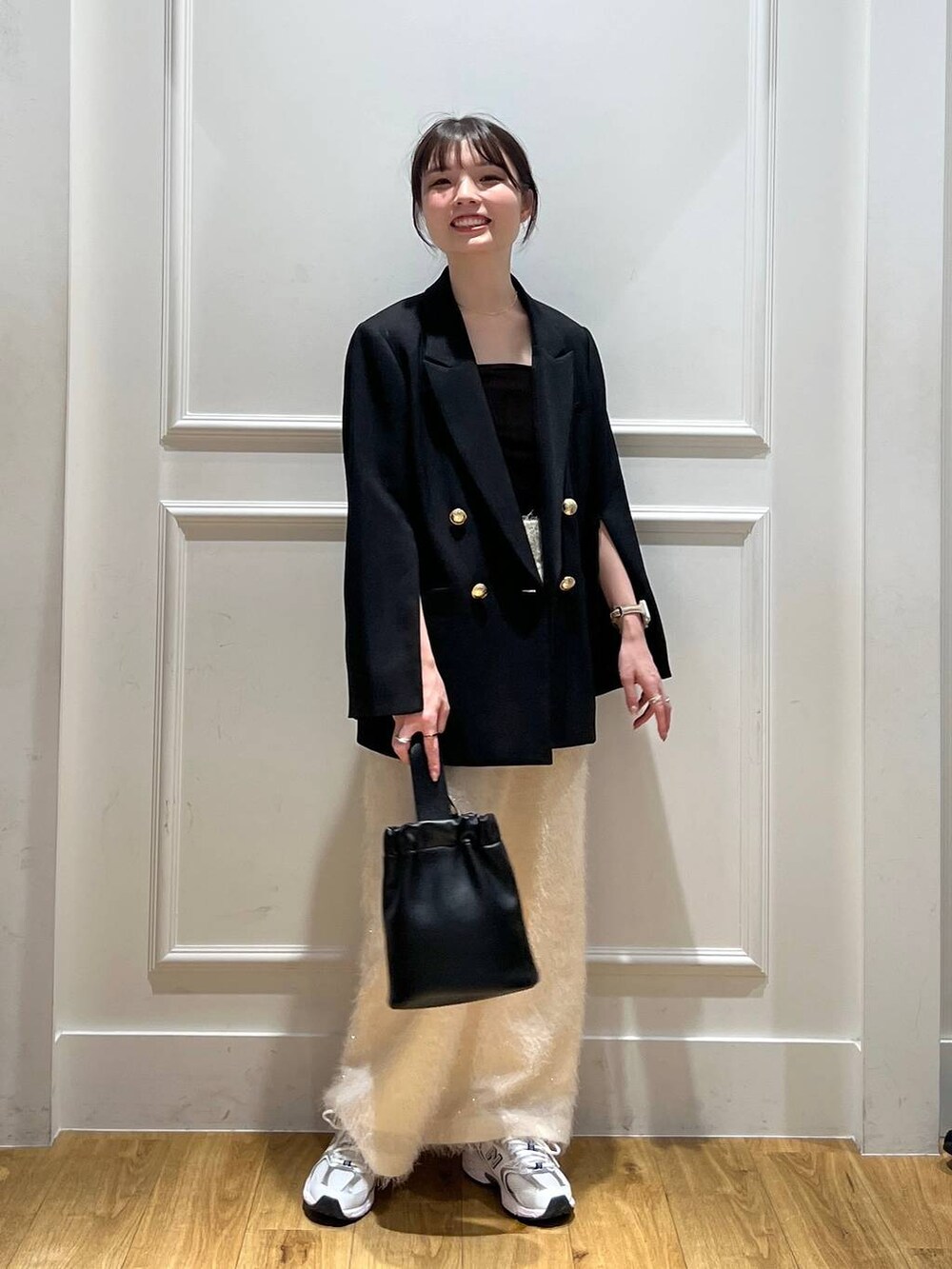 ブラック系のテーラードジャケット、ブラック系のショルダーバッグ、ブラウン系のタンクトップを着用したレディースの秋コーディネートの5枚目の写真