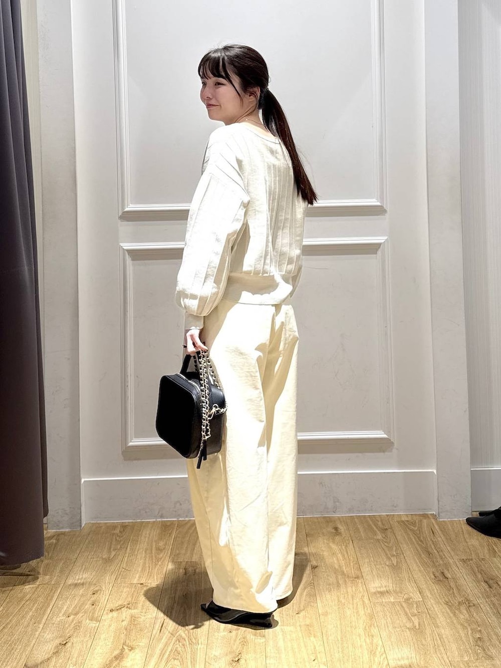 ホワイト系のカーディガン/ボレロ、ブラック系のサンダル、ブラック系のショルダーバッグを着用したレディースの春コーディネートの3枚目の写真