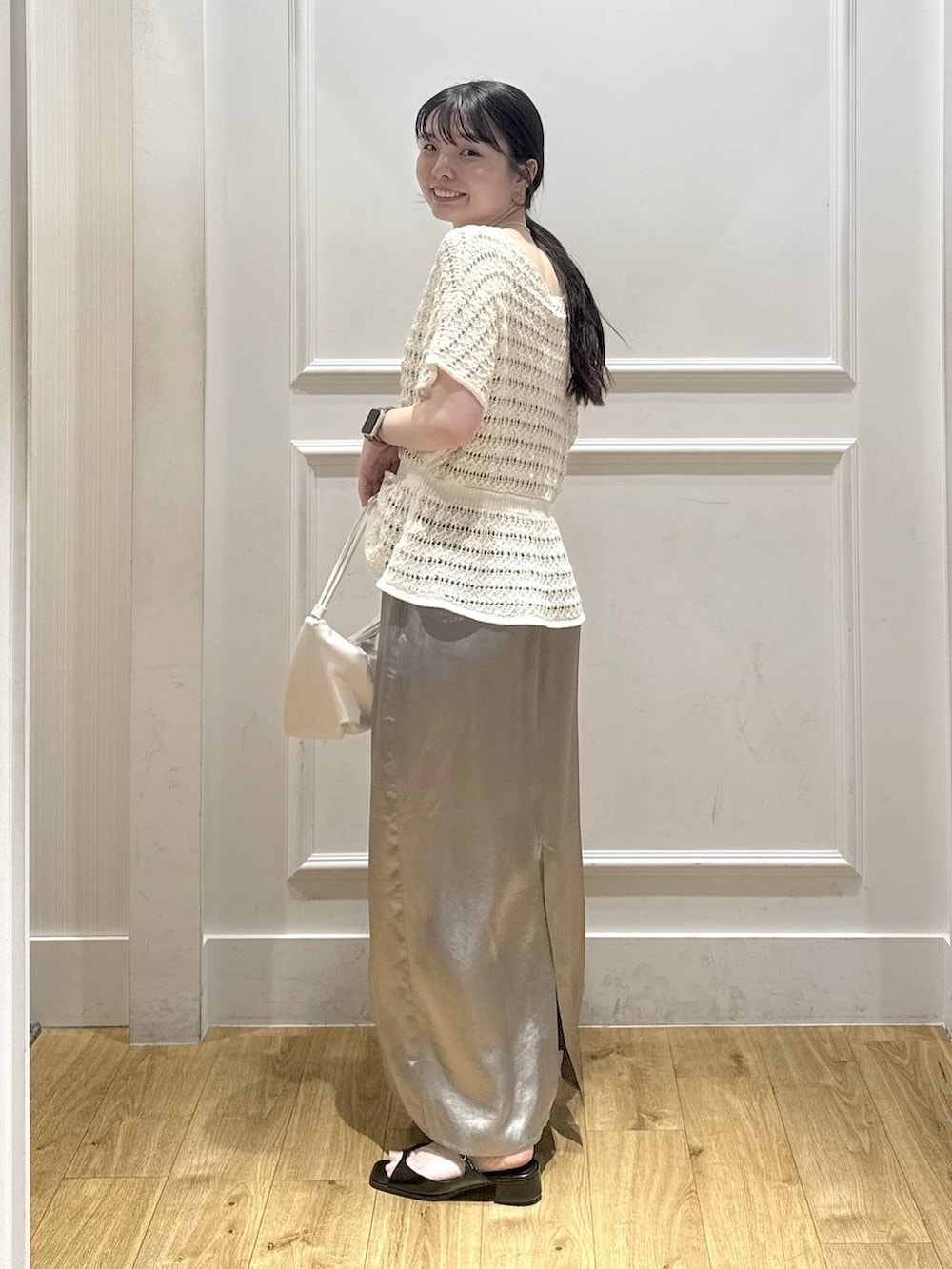 ホワイト系のショルダーバッグ、ブラック系のパンプス、グレー系のスカートを着用したレディースの夏コーディネートの3枚目の写真