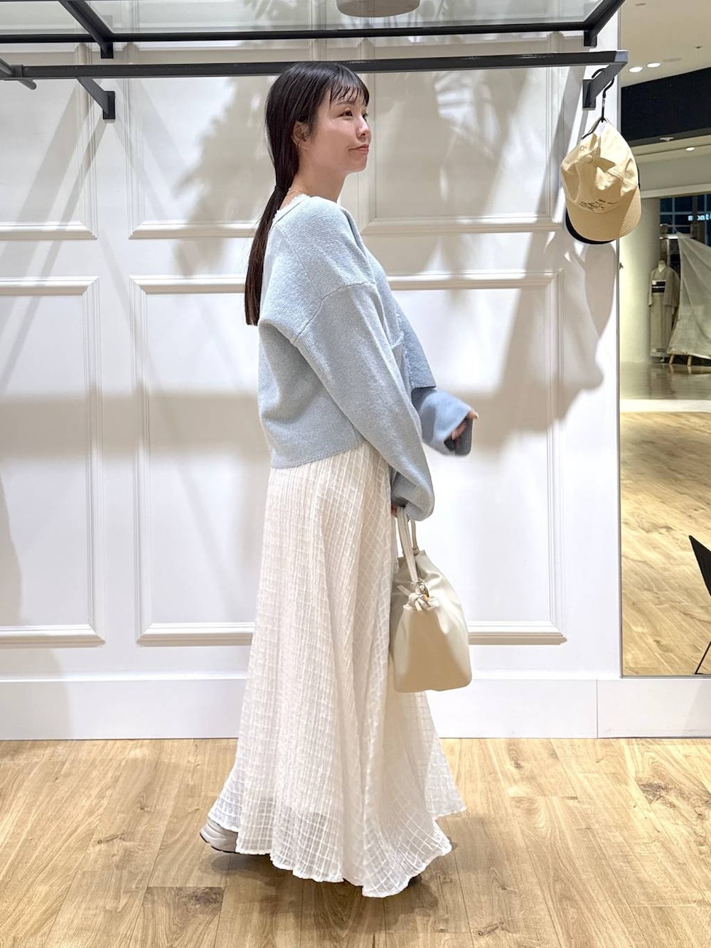 ブルー系のカーディガン/ボレロ、ホワイト系のスカートを着用したレディースの春コーディネートの2枚目の写真