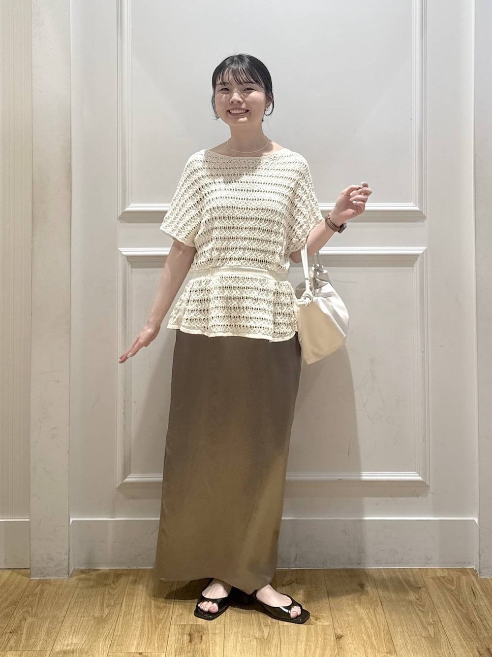 ホワイト系のショルダーバッグ、ブラック系のパンプス、グレー系のスカートを着用したレディースの夏コーディネートの5枚目の写真