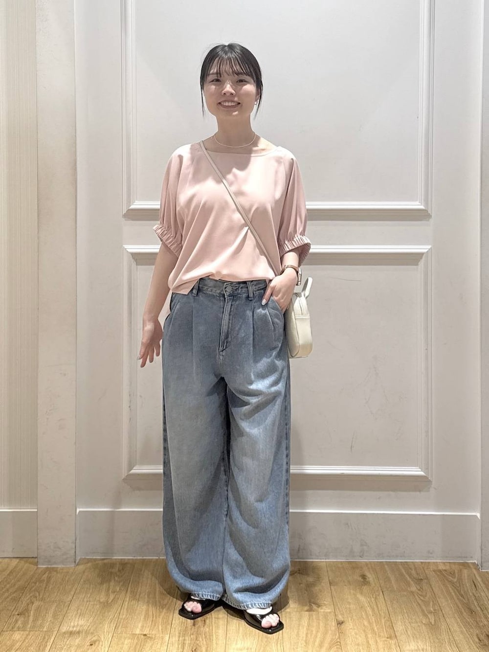 ピンク系のシャツ/ブラウス、ブルー系のデニムパンツ、ブラック系のパンプスを着用したレディースの夏コーディネートの5枚目の写真