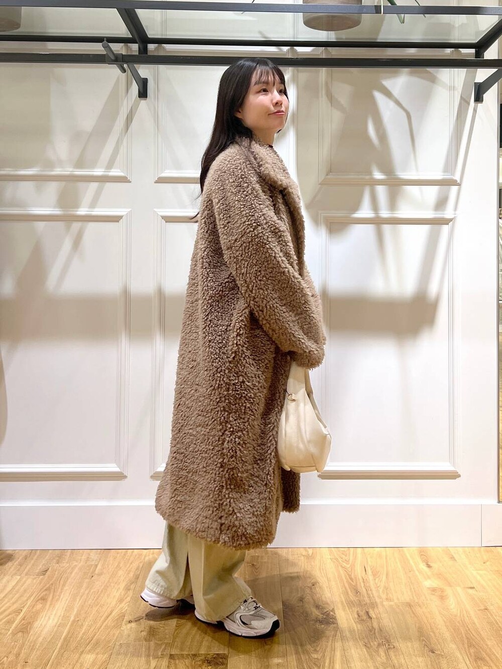 ベージュ系のデニムパンツ、ホワイト系のハンドバッグ、ベージュ系のその他アウターを着用したレディースの冬コーディネートの2枚目の写真
