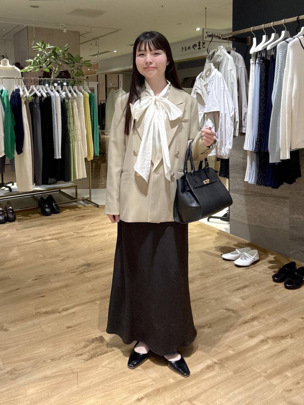 ホワイト系のシャツ/ブラウス、ベージュ系のテーラードジャケット、ブラック系のショルダーバッグを着用したレディースの春コーディネートの4枚目の写真