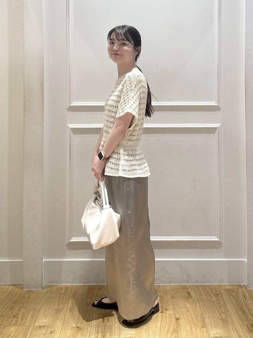 ホワイト系のショルダーバッグ、ブラック系のパンプス、グレー系のスカートを着用したレディースの夏コーディネートの4枚目の写真
