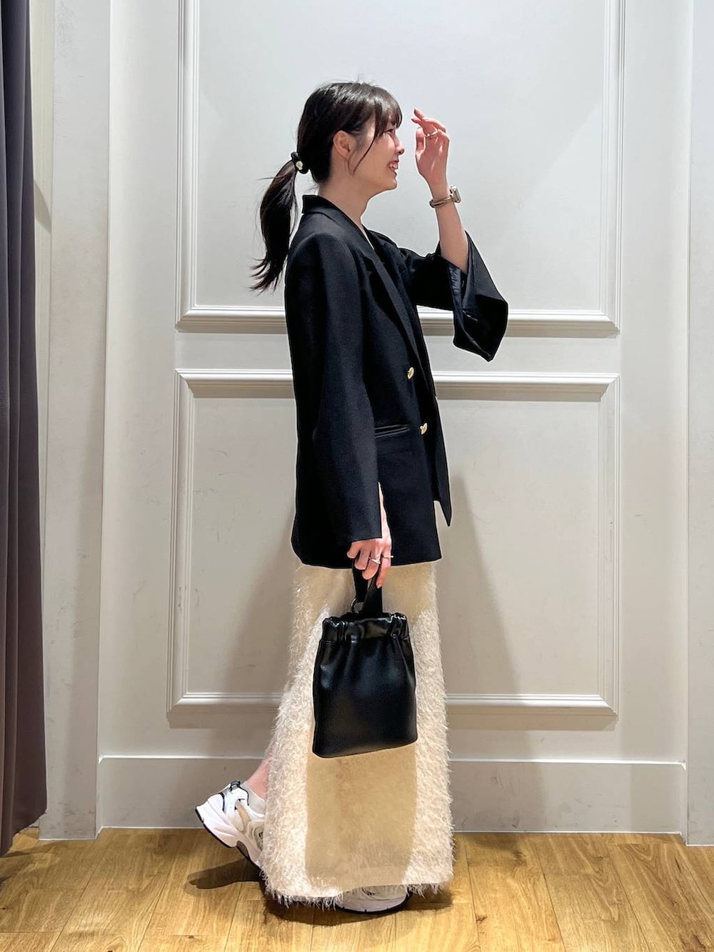 ブラック系のテーラードジャケット、ブラック系のショルダーバッグ、ブラウン系のタンクトップを着用したレディースの秋コーディネートの4枚目の写真