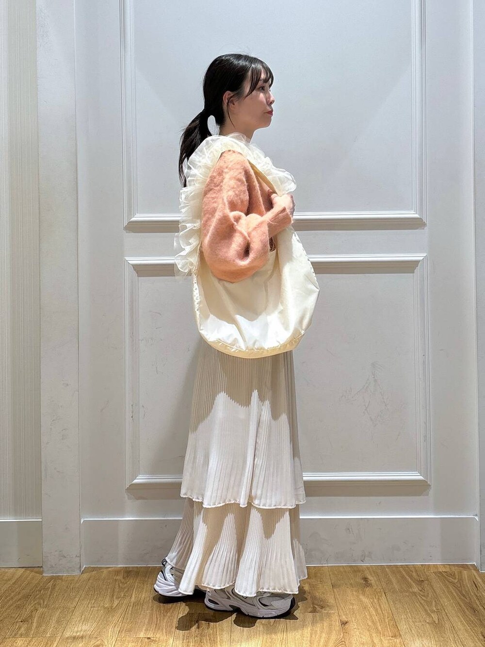 ホワイト系のスニーカー、ピンク系のカーディガン/ボレロ、ホワイト系のスカートを着用したレディースの秋コーディネートの4枚目の写真