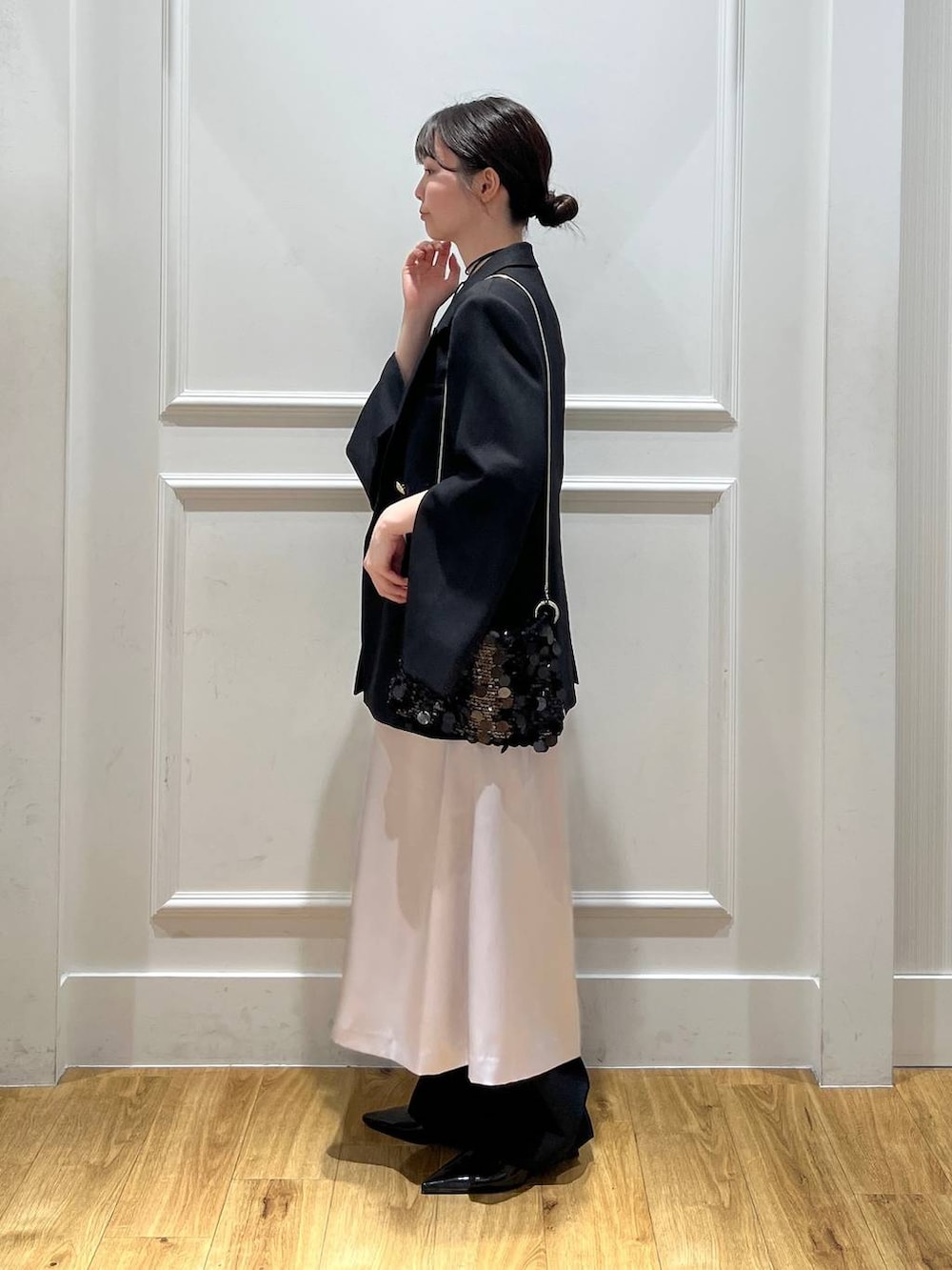 ブラック系のテーラードジャケット、ブラック系のトートバッグ、ブラック系のスラックスを着用したレディースの秋コーディネートの2枚目の写真