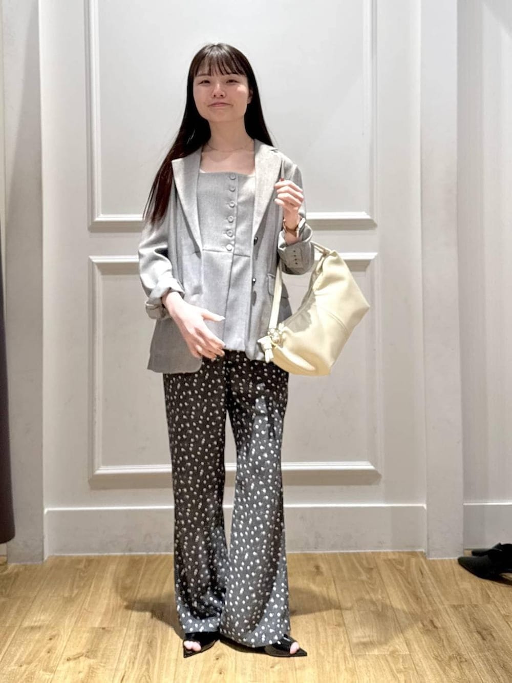 ブラック系のノーカラージャケット、ブラック系のベスト、ブラック系のサンダルを着用したレディースの春コーディネートの5枚目の写真