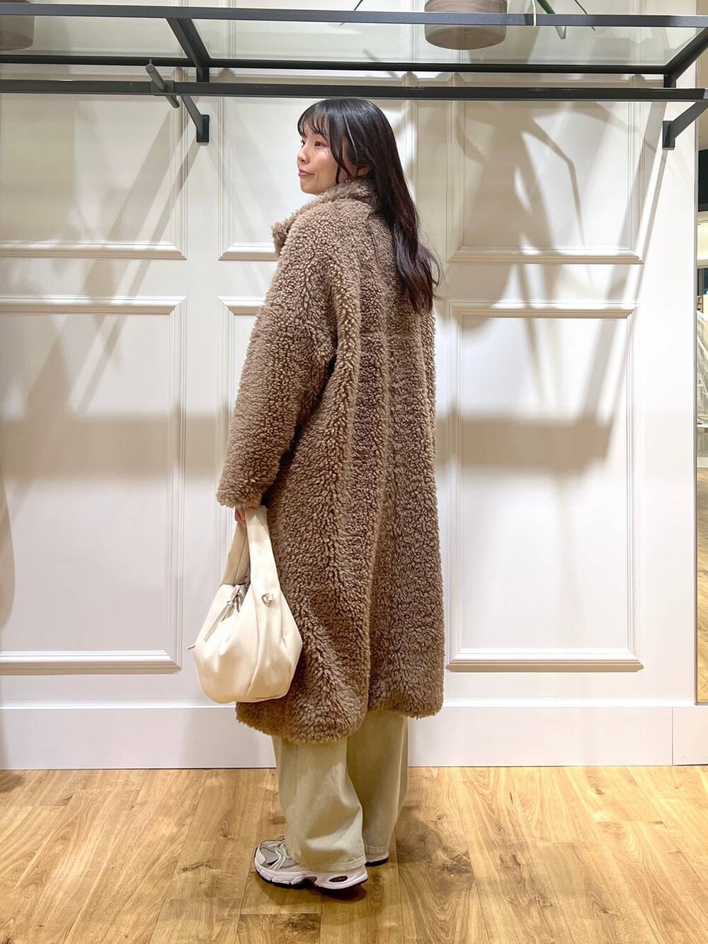 ベージュ系のデニムパンツ、ホワイト系のハンドバッグ、ベージュ系のその他アウターを着用したレディースの冬コーディネートの3枚目の写真