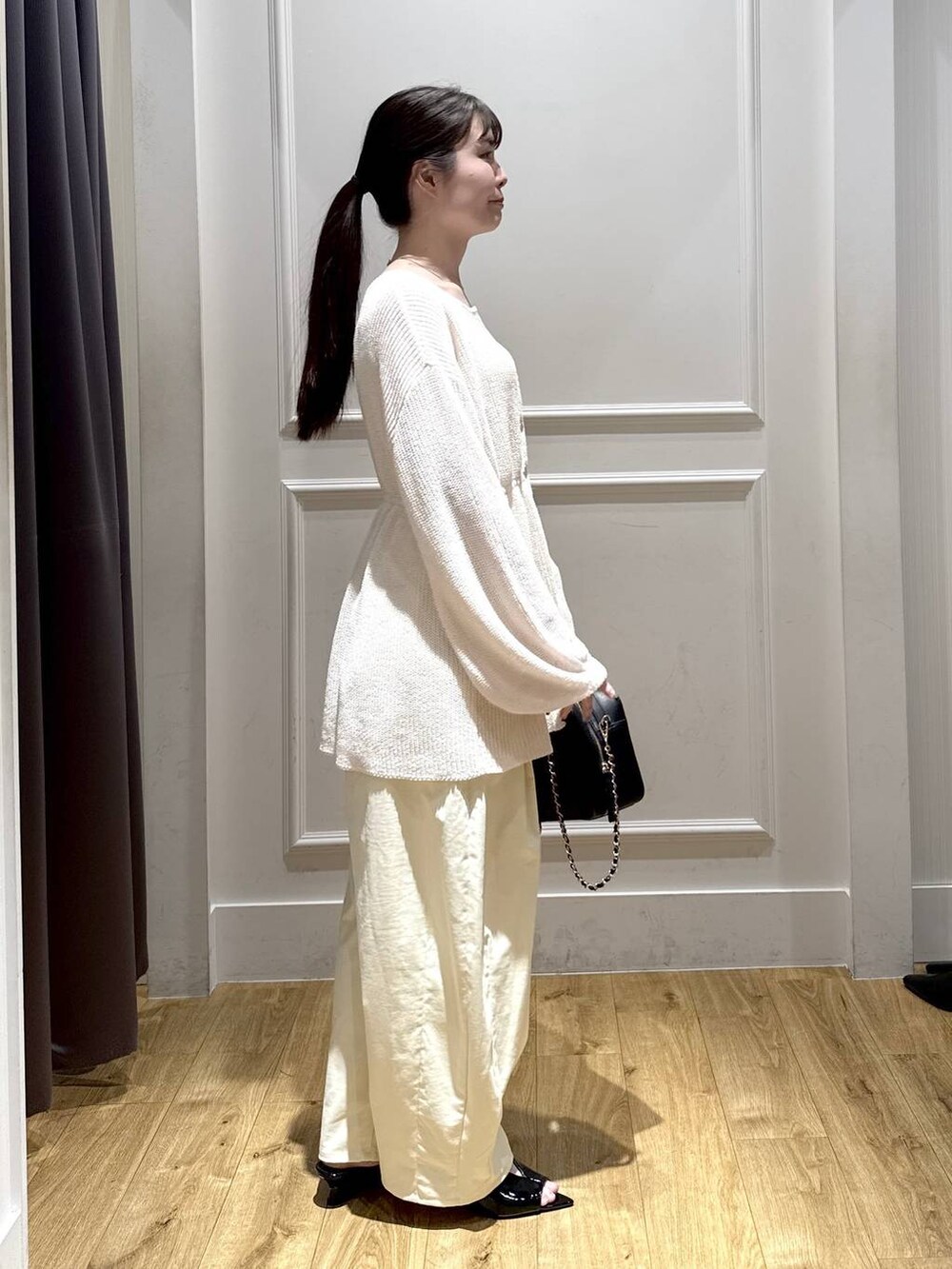 ホワイト系のカーディガン/ボレロ、ブラック系のサンダル、ブラック系のショルダーバッグを着用したレディースの春コーディネートの4枚目の写真