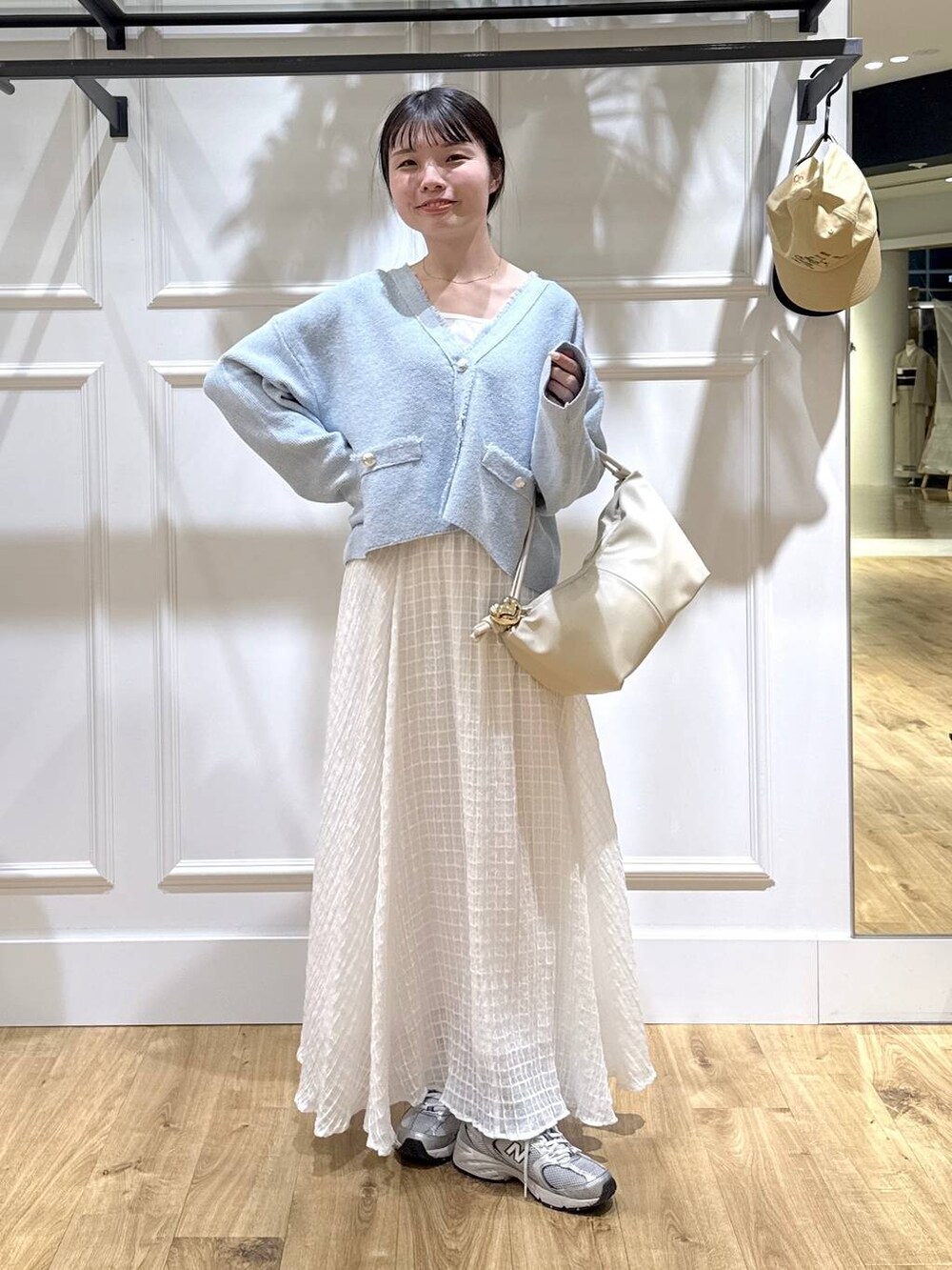 ブルー系のカーディガン/ボレロ、ホワイト系のスカートを着用したレディースの春コーディネートの5枚目の写真