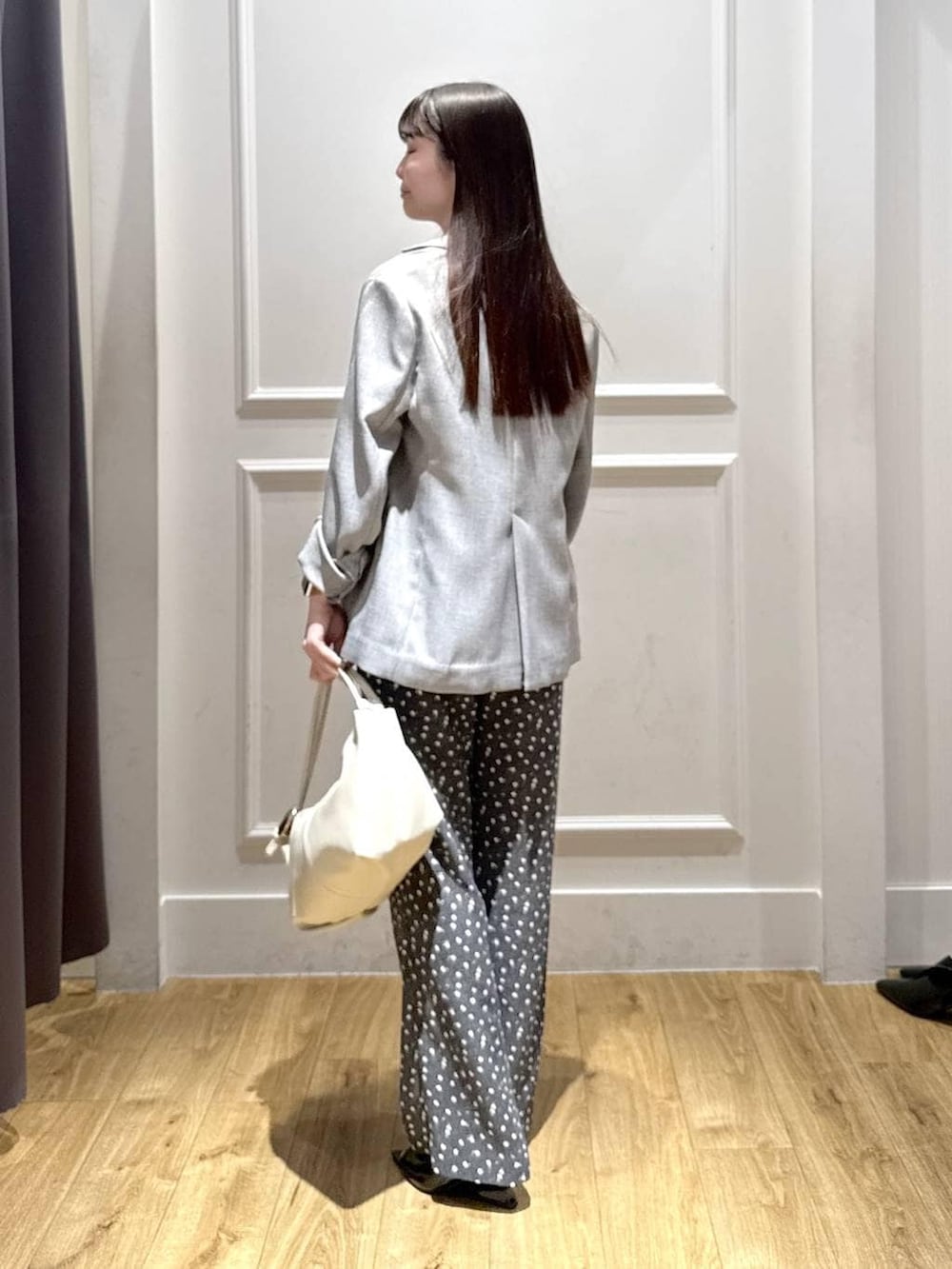 ブラック系のノーカラージャケット、ブラック系のベスト、ブラック系のサンダルを着用したレディースの春コーディネートの3枚目の写真