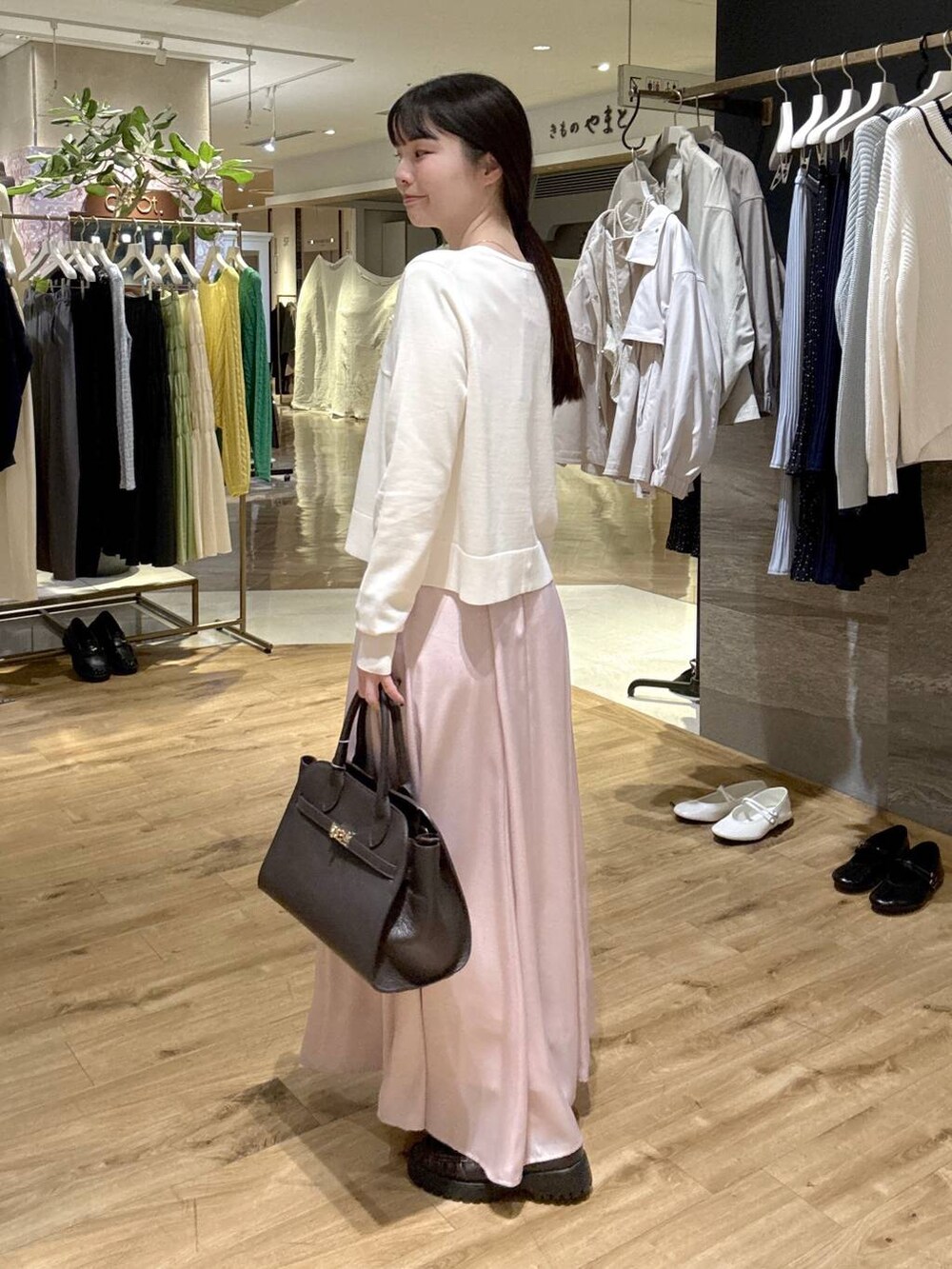 ピンク系のスカート、ブラウン系のローファー、ブラック系のショルダーバッグを着用したレディースの春コーディネートの3枚目の写真