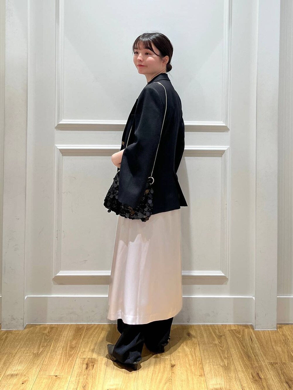 ブラック系のテーラードジャケット、ブラック系のトートバッグ、ブラック系のスラックスを着用したレディースの秋コーディネートの3枚目の写真