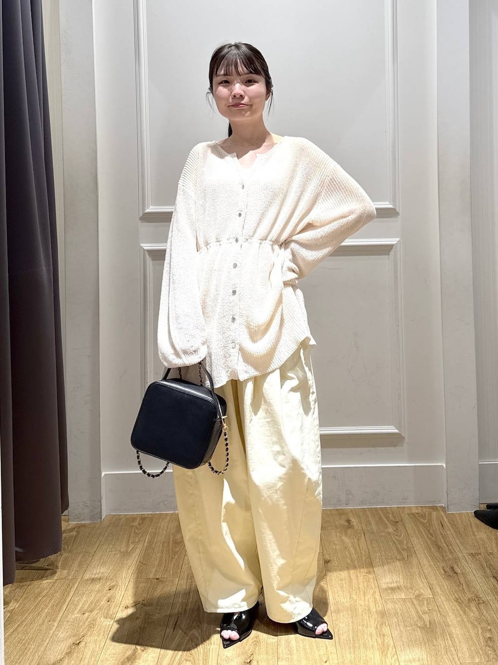 ホワイト系のカーディガン/ボレロ、ブラック系のサンダル、ブラック系のショルダーバッグを着用したレディースの春コーディネートの5枚目の写真