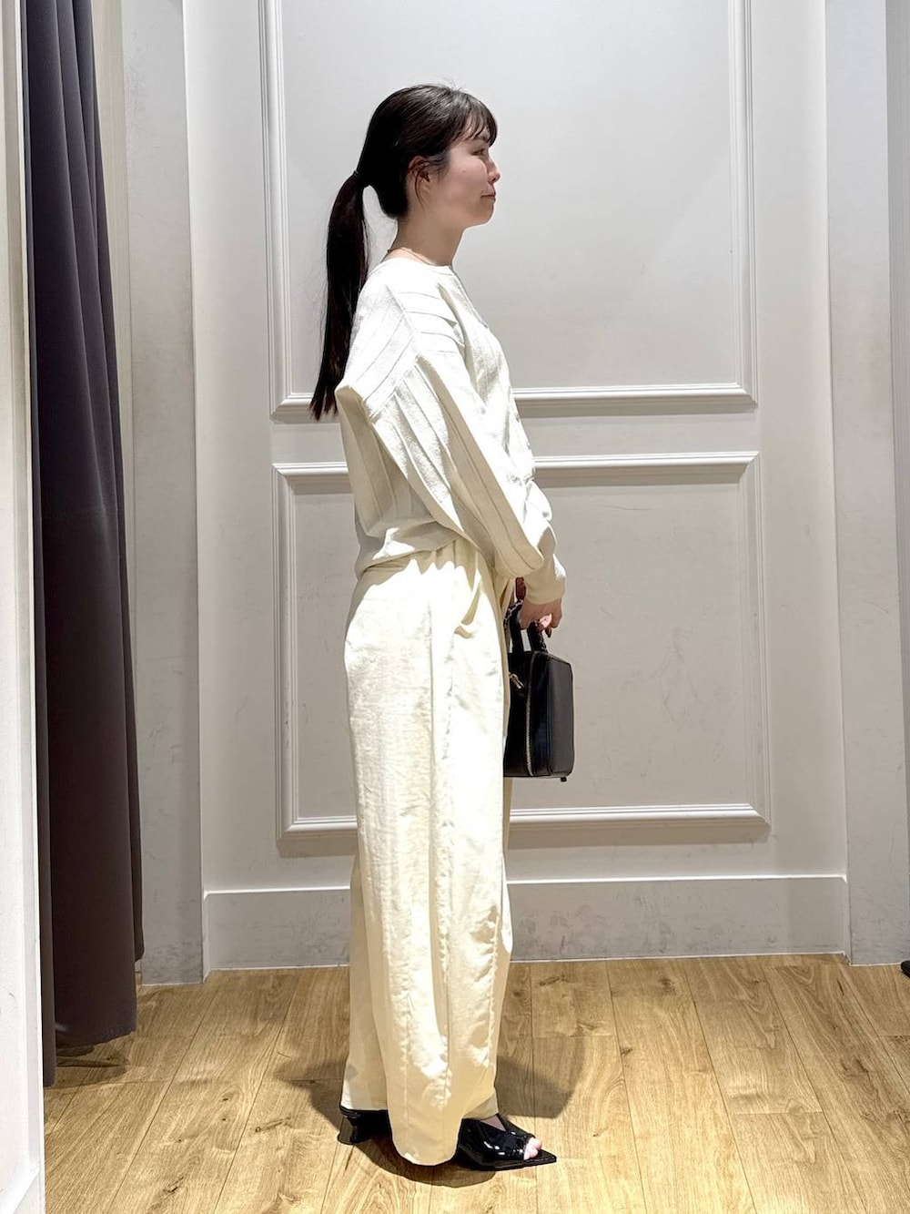 ホワイト系のカーディガン/ボレロ、ブラック系のサンダル、ブラック系のショルダーバッグを着用したレディースの春コーディネートの2枚目の写真